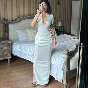 Detail view of white deep V-neck maxi dress with waist ruffles and side slit design