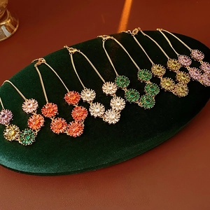 Detail of colorful crystal flower bracelets in gold finish on a luxury velvet display