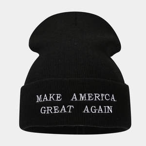 Close-up of white letter embroidery on a black cuffed knit beanie with fine stitching