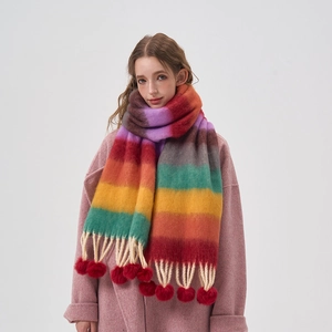 Rainbow striped scarf with cozy pom-poms and fringe worn by a model in winter style
