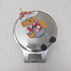 Detail eines Bärenanhängers mit Perlenbeinen und Schneeflockenknopf für Weihnachten