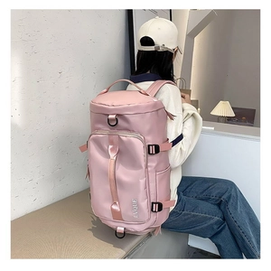 Pink large travel backpack with adjustable straps and front pocket shown on a model