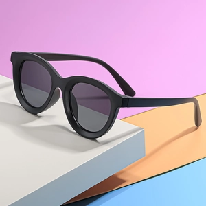 Kids round matte black sunglasses with dark grey UV lenses on colorful geometric background