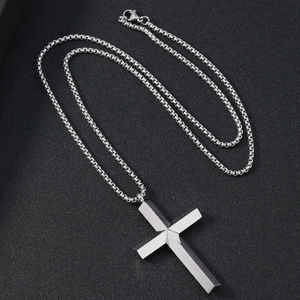 Polished silver stainless steel cross pendant necklace with woven chain on black background