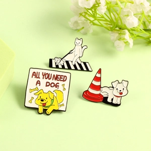 Close-up of three cute cartoon animal enamel pins featuring a cat and dog on green background