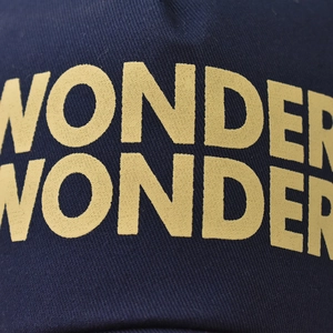 Cappellino da baseball in cotone blu scuro con ricamo giallo WONDER in dettaglio