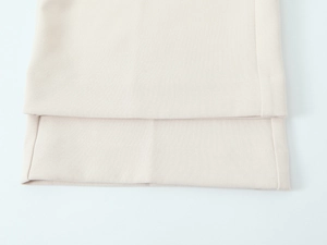 Dettaglio del blazer beige doppiopetto che mostra cuciture fini e trama del tessuto