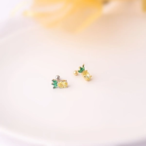 Detailed macro shot of pineapple fruit stud earrings with yellow and green crystals