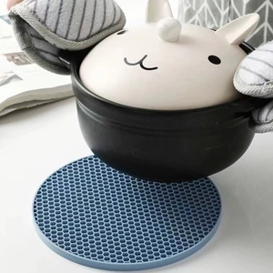 Dessous de plat rond en silicone bleu protégeant la table d'une cocotte chaude