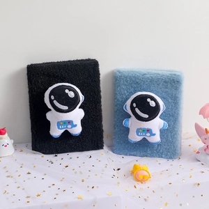 Pair of plush absorbent wristbands in black and blue with cute astronaut embroidery