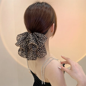 Detailed view of an oversized leopard print hair scrunchie made of layered mesh fabric