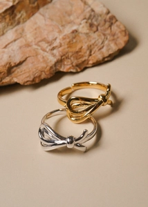 Detail of adjustable 925 silver knot rings in gold and silver finish on stones