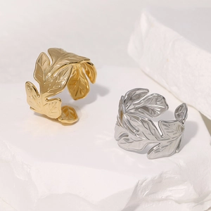 Minimalistische Edelstahlringe mit Blattdesign in Gold und Silber auf Stein