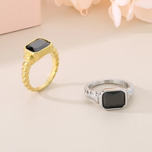 Detail of square black gemstone ring with twisted band texture in gold and silver