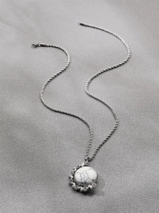 Détail du collier chaîne torsadée argentée avec pendentif marbre et strass brillants