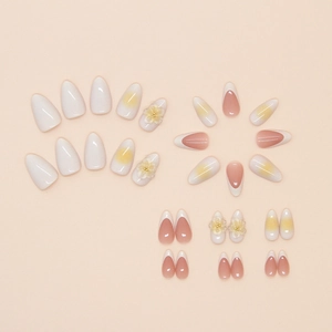 Detail of almond press-on nails featuring French tips, ombre effects and 3D floral accents