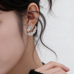 Silver feather leaf earrings with zircons shown on model in a high-fashion side view