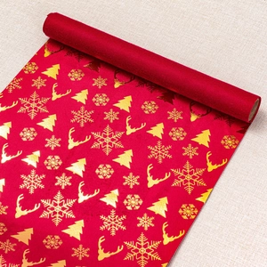 Detail of red velvet table runner featuring golden Christmas reindeer and snowflake prints