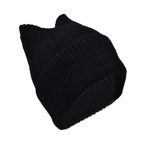 Macro view of textured ribbed knit pattern on a black cat-ear shaped winter beanie