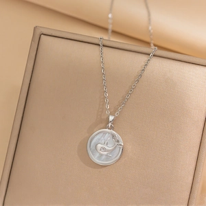 Silver whale shell necklace with fine diamonds on an elegant gold jewelry box