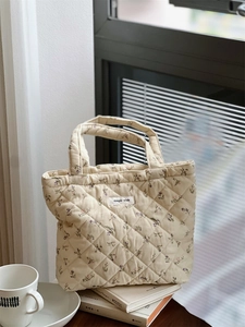 Détail du sac cabas matelassé à fleurs avec étiquette simple wish et texture en coton