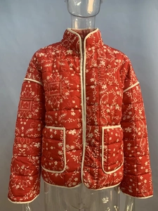 Detail of red quilted jacket with paisley heart prints, stand collar and two large pockets