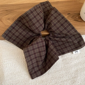 Detail of dark brown plaid fabric texture on a minimalist layered scrunchie hair tie