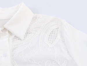 Close-up of intricate lace embroidery and floral patterns on white French style shirt
