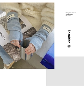 Detail of light blue knitted fingerless gloves with white label in use for typing