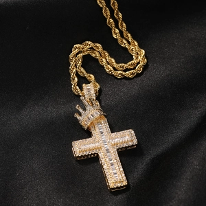 Close-up of gold crown cross pendant with cubic zirconia on thick rope chain