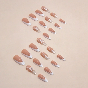 Faux ongles amande french rose nude avec perles papillon et accents floraux délicats
