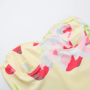 Gros plan détaillé de la robe fleurie jaune avec décolleté plissé à volants et texture