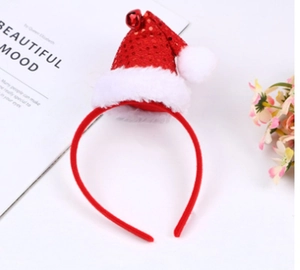Detail of a festive red sequined Christmas hat headband with white plush pom and bell