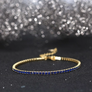 Macro shot of gold adjustable bracelet with blue square-cut cubic zirconia crystals