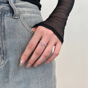 Lifestyle view of a heart-shaped pink diamond silver ring worn by a model in denim