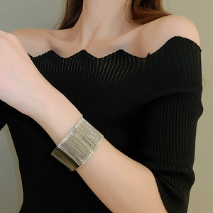Close-up of wide multi-layer silver twisted metal bangle worn on a female wrist