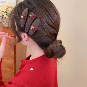 Three-piece set of brown plush hair clips with cherry and gold bow details on hair