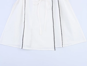 Vue détaillée de l'ourlet blanc avec coutures noires contrastées et lien de serrage