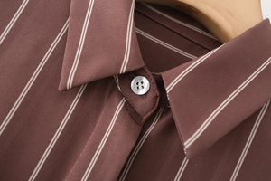 Close-up of lapel collar and buttons on coffee brown striped shirt with fine stitching
