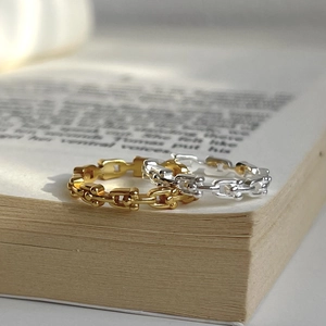 Close-up of gold and silver chain link rings on an open book for vintage style