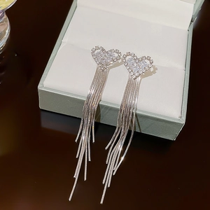 Detail of silver heart tassel earrings with zircon inlay on a jewelry display box