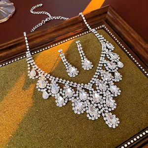 Macro shot of a teardrop-shaped rhinestone necklace and earrings in a vintage frame