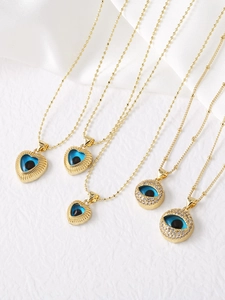 Detailed close-up of 18k gold plated heart and disc necklaces with zircon evil eye charms