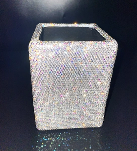 Sparkling crystal makeup brush holder with iridescent rhinestones on a black background