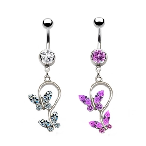 Détail macro des piercings de nombril papillon avec zircons blancs et violets brillants