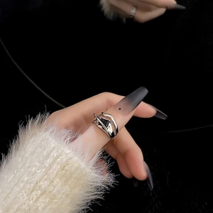 Macro shot of silver ring with black zircon stone on hand over dark background