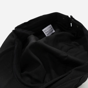 Detail view of the 100% cotton inner lining and wash label of a black beret hat