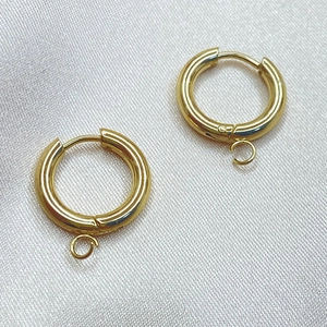 Minimalist golden titanium steel hoop earrings with hanging loop on white silk background