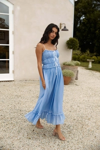 Détail d'une robe maxi bleu ciel à volants avec de fines bretelles blanches délicates