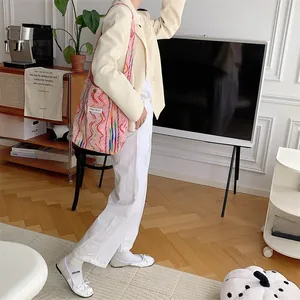 Gros plan détaillé du sac cabas en toile rayé arc-en-ciel aux motifs ondulés colorés